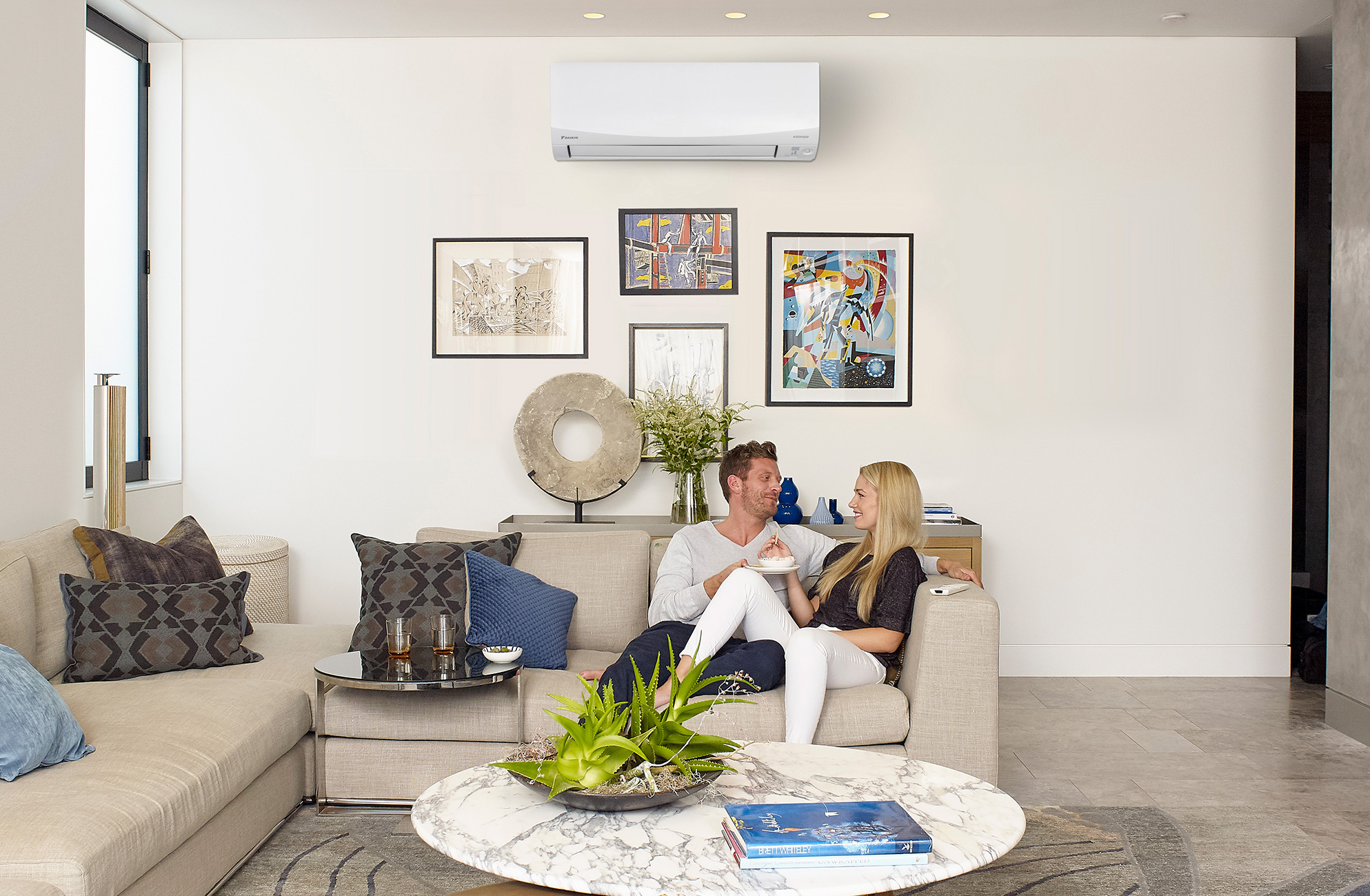 Image of a couple relaxing on a sofa, enjoying the cool comfort of an air conditioner.