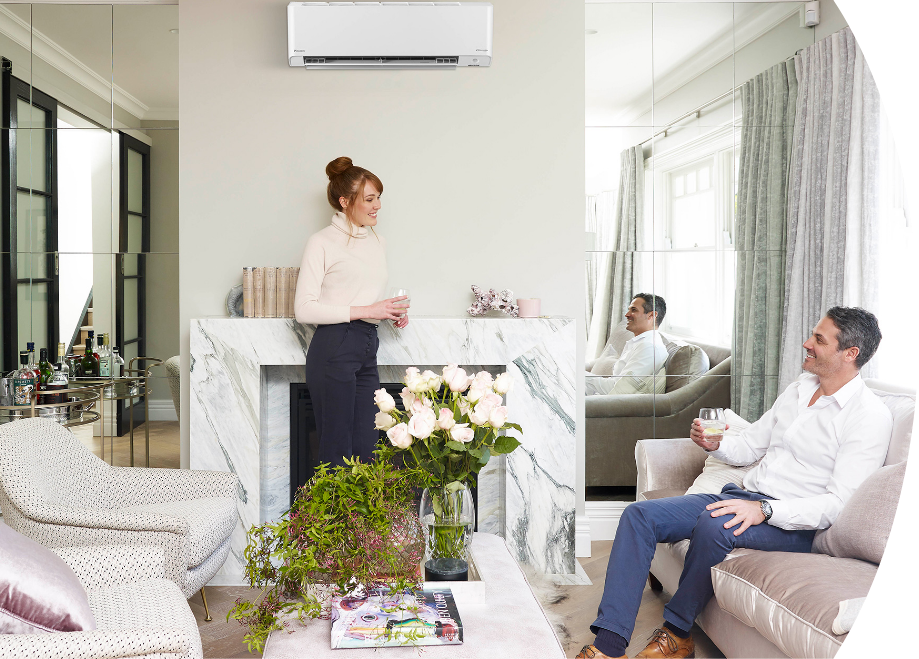 A couple engaged in a conversation in their cozy living room, with a modern air conditioning unit.